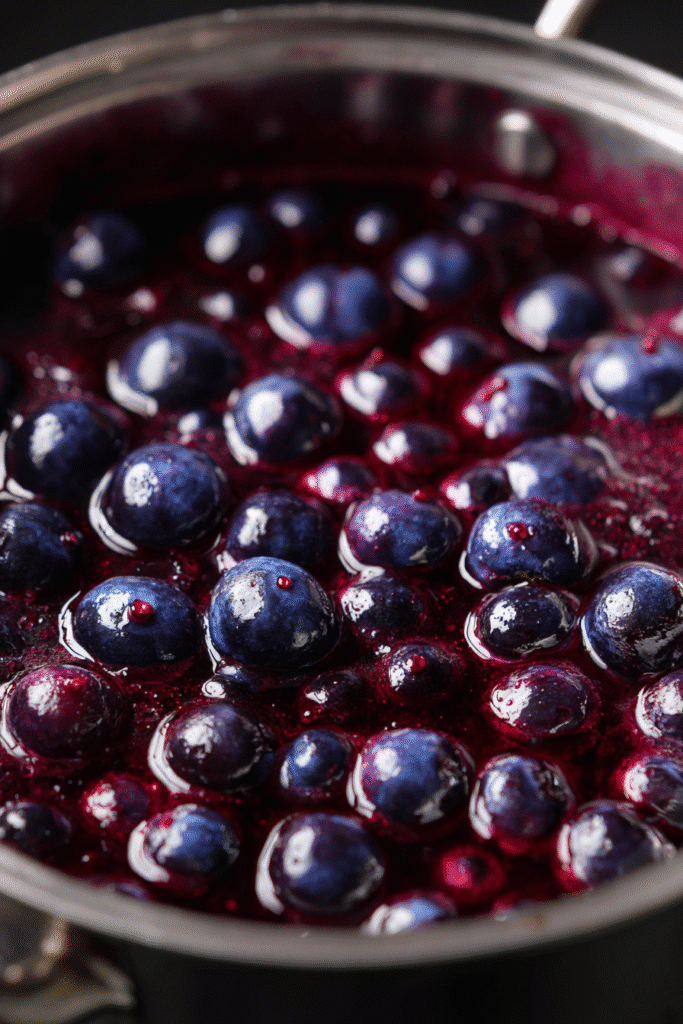 Blueberry topping for cream cake simmering in pot